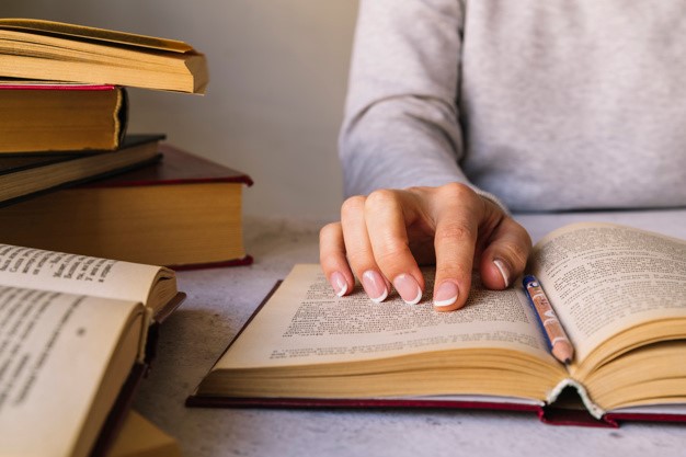 pessoa-estudando-ao-lado-da-pilha-de-livro_23-2147978228