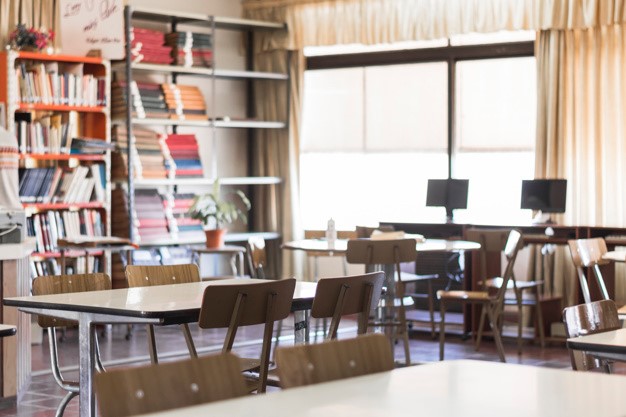 cadeiras-e-mesas-na-sala-de-aula-vazia_23-2147863493