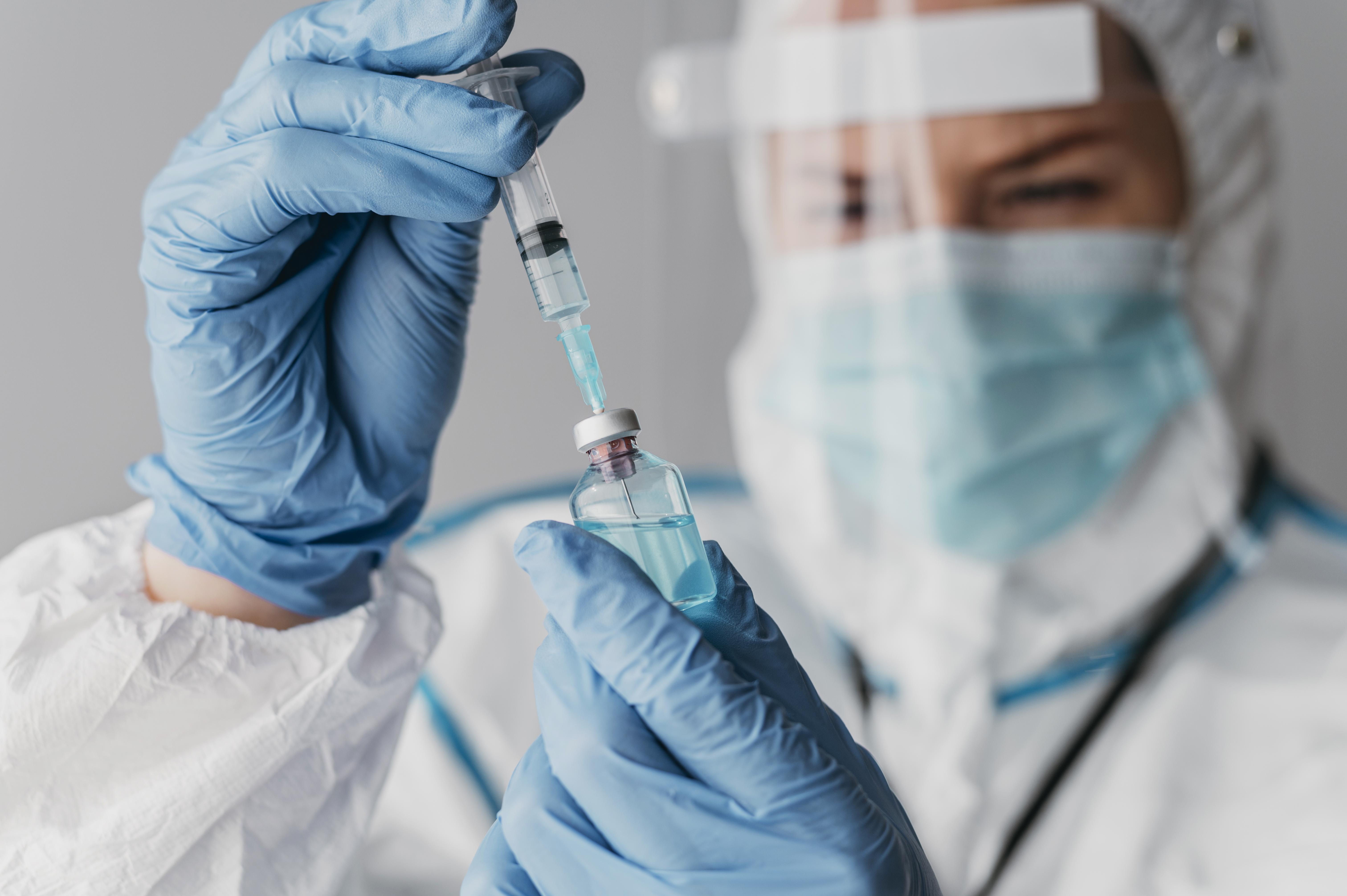 doctor-holding-preparing-vaccine-while-wearing-protective-equipment|||Fotógrafo:Freepik