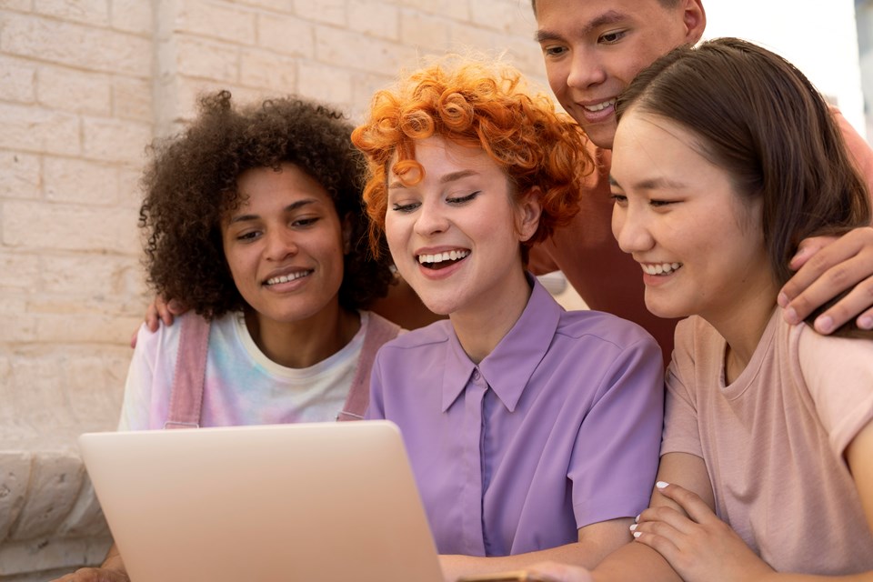 feche-amigos-sorridentes-com-laptop