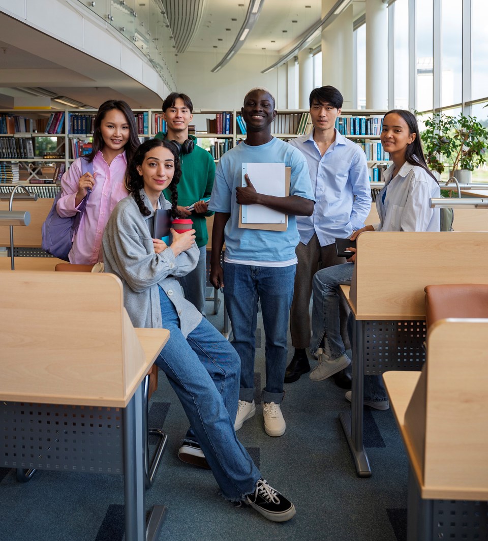 full-shot-smiley-students-library2|||Fotógrafo:Freepik