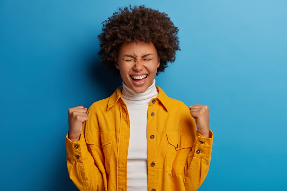 happy-dark-skinned-woman-enjoys-moment-of-success-celebrates-victory-or-great-result-feels-joyful-gains-important-goal-or-achievement
