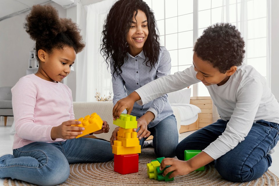 mae-sorridente-brincando-em-casa-com-os-filhos