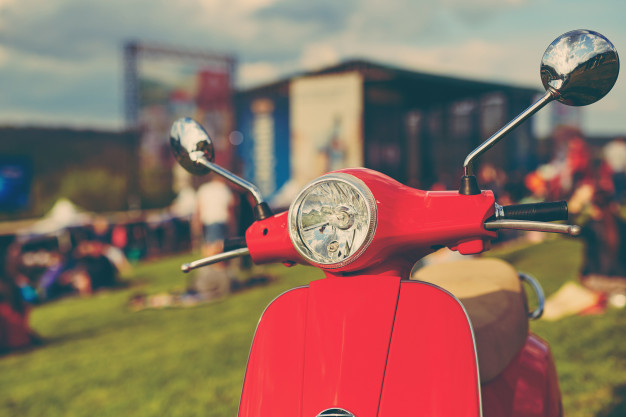 red-retro-scooter-grass_158595-1906
