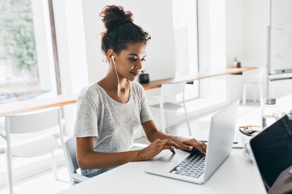 romantic-african-woman-with-trendy-hairstyle-sitting-her-workplace-analysing-data-indoor-portrait-black-female-student-working-with-laptop-before-exam