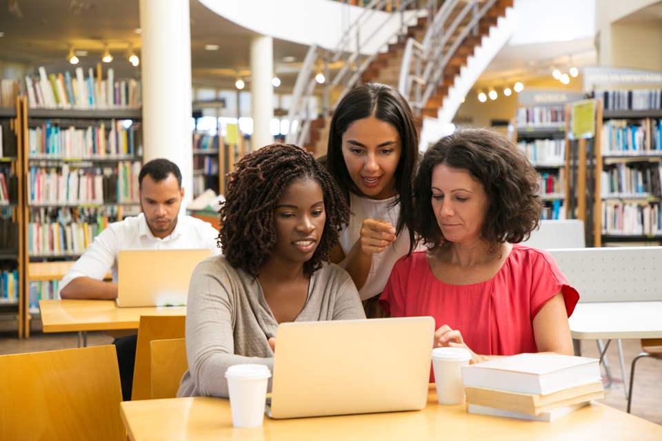 smiling-women-working-with-laptop-public-library (1)|||Fotógrafo: Divulgação Freepik